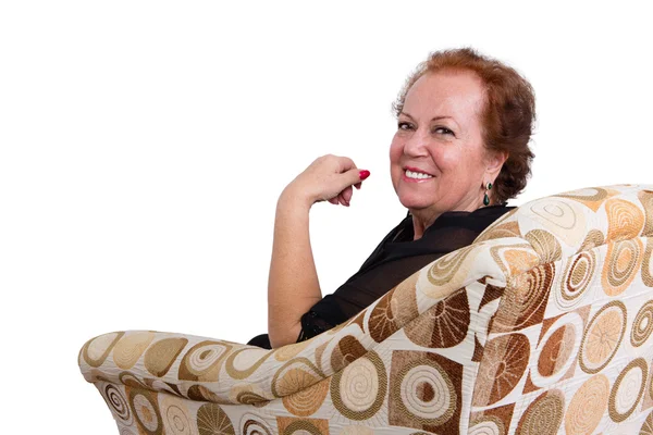 Uśmiechający się starszy kobieta siedzi na kanapie — Zdjęcie stockowe