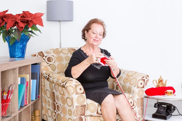 Χαρούμενη ηλικιωμένη κυρία που απολαμβάνει το πλέξιμο — Φωτογραφία Αρχείου