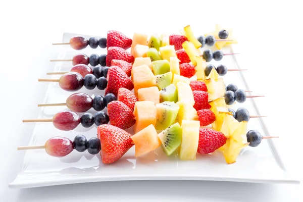 Serving of colorful fresh fruit kebabs — Stock fotografie