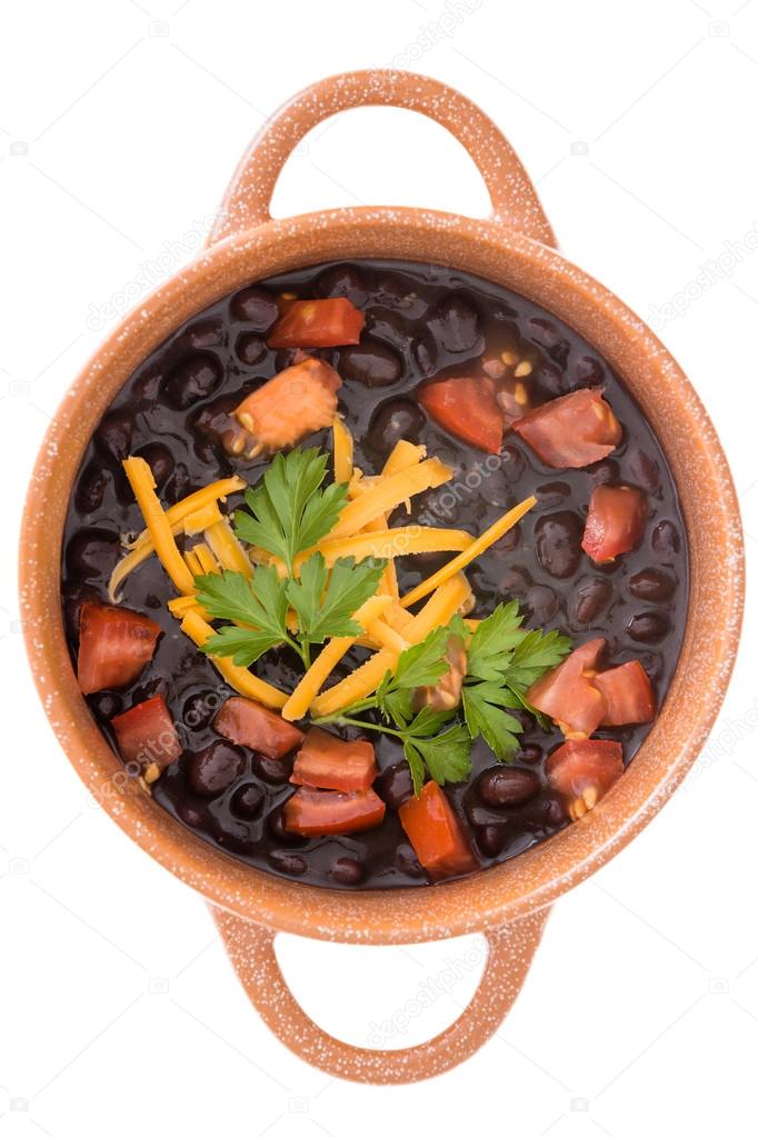 Bowl of black bean soup garnished with cheese