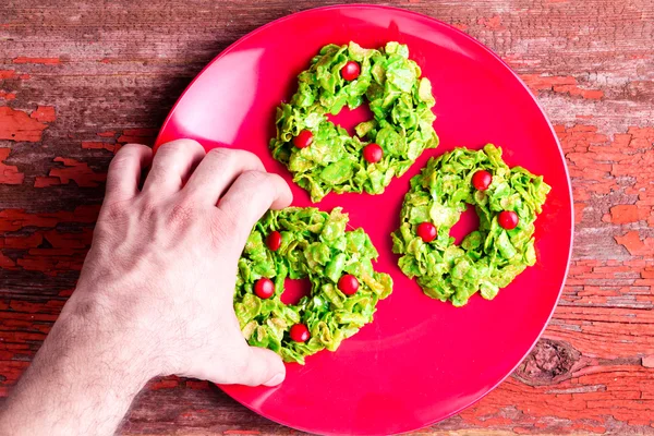 Man plockar upp en säsongsbetonad jul krans cookie — Stockfoto