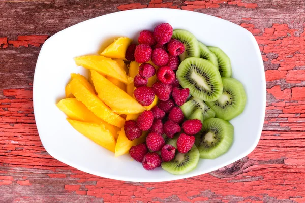 Πολύχρωμα φρούτα στο πιάτο στο τραπέζι — Φωτογραφία Αρχείου