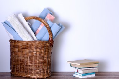 Kilim sepet ve beyaz duvara kazıklı kitaplar