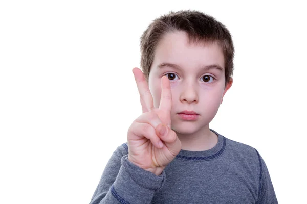 Allvarlig pojke med två fingrar upp — Stockfoto