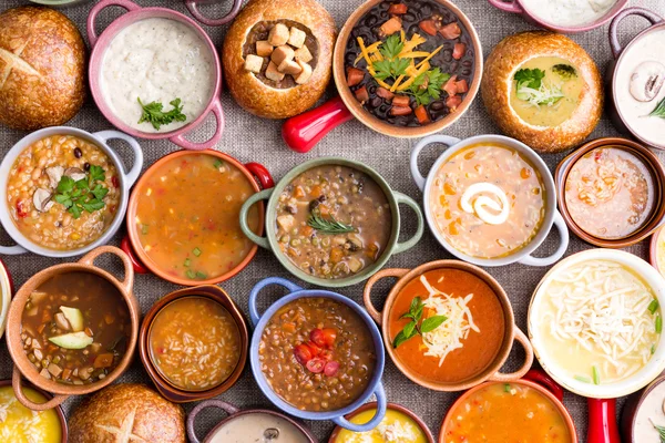 Verschillende gegarneerde soepen in kleurrijke kommen — Stockfoto