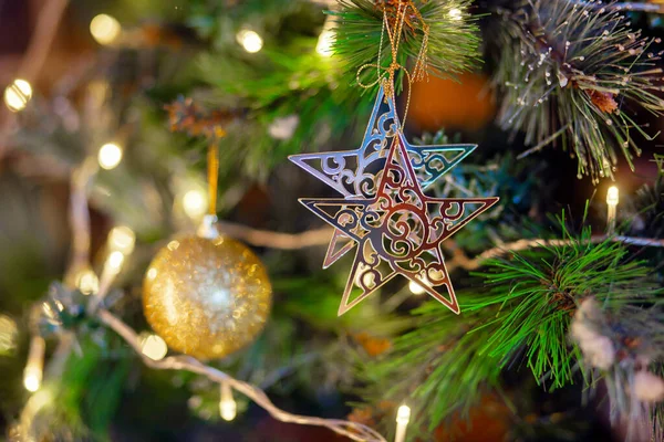 Étoile d'or accrochée à la branche du sapin de Noël. Décoration d'arbre de Noël — Photo