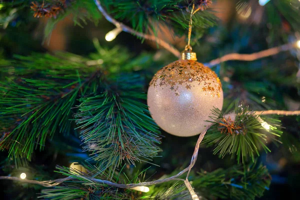 Boule dorée accrochée à une branche d'un arbre de Noël. Décoration d'arbre de Noël. Préparation des vacances, guirlande. — Photo