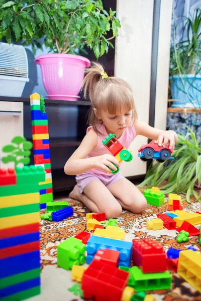 Uma Menina Senta Chão Casa Joga Construtor Plástico Multicolorido Uma — Fotografia de Stock