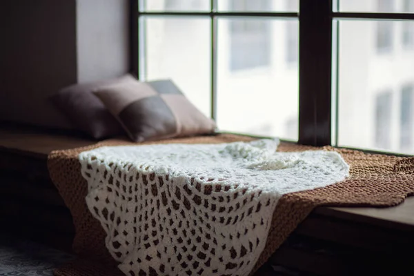 Janela de inverno. Cama de malha quente no peitoril da janela com travesseiros — Fotografia de Stock