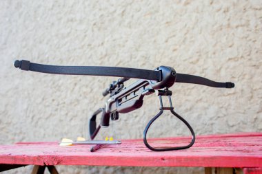 Oklu ve optik manzaralı modern bir tatar yayı caddedeki ahşap bir masada yatıyor.