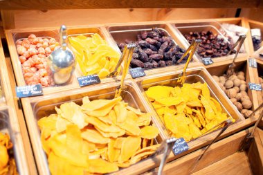 Mağazada birçok farklı kurutulmuş egzotik meyve ağırlıkla satılır. Mango, tarihler ve kumkatlar dükkandaki tezgahın üzerinde.