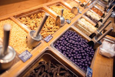 Mağazadaki tezgahta birçok farklı fındık satılıyor. Satılık çok sayıda fındık var. Egzotik bir mağazada self servis.