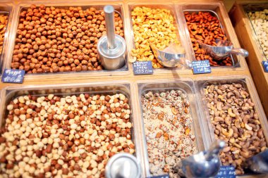 Mağazadaki tezgahta birçok farklı fındık satılıyor. Satılık çok sayıda fındık var. Egzotik bir mağazada self servis.