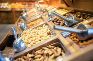 Mağazadaki tezgahta birçok farklı fındık satılıyor. Satılık çok sayıda fındık var. Egzotik bir mağazada self servis.