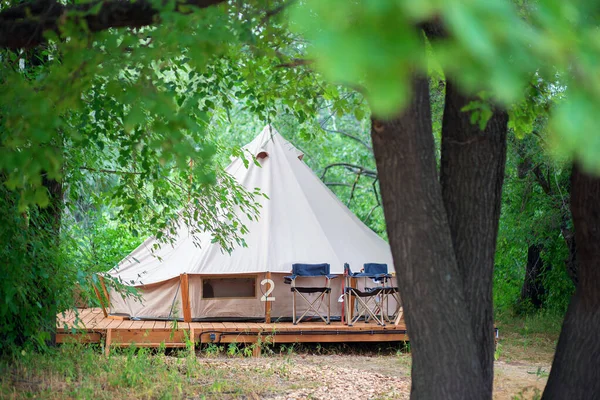 Glamping bölgesindeki modern kamp çadırlarının manzarası. Her türlü konfora sahip bir kamp çadırı. Ormandaki medeniyet.