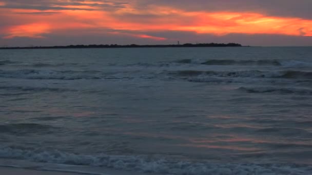 Playa después del atardecer con faro lejos — Vídeo de stock