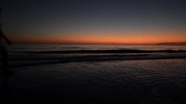 Kumsalda yürüyen kız.