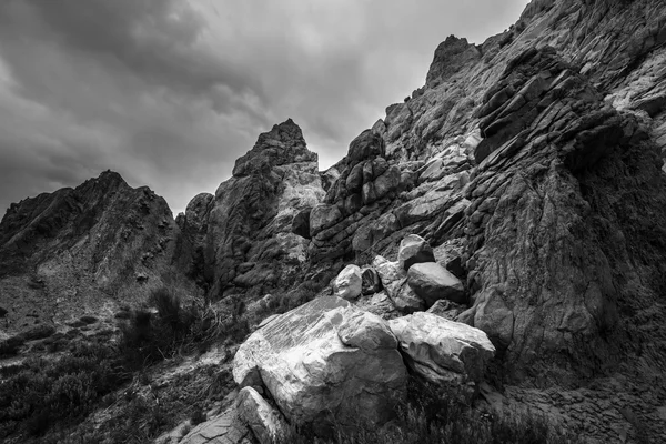 Schwarze und weiße Felsformationen mit dramatischem Baumwollhimmel — Stockfoto