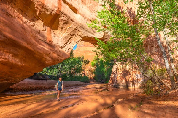 Menina Backpacker caminhando sob Arco Ponte Natural Coyote Gulch — Fotografia de Stock