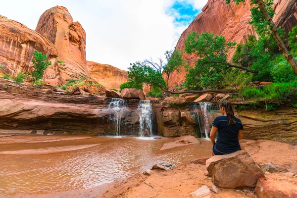 Girl sitting in front of Waterfall — Stock Photo, Image