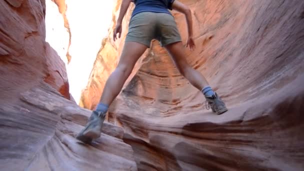 Meisje wandelaar klimmen smalle deel van Peekaboo Gulch Canyon — Stockvideo