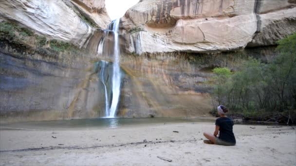 Meditando cerca de la cascada — Vídeos de Stock