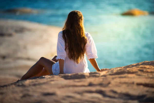 Mulher bonita relaxante na praia ao pôr-do-sol — Fotografia de Stock