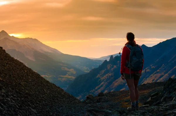 Mochilero chica mirando atardecer colorado montañas — Foto de Stock