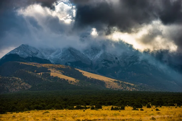 Sun shining through the dark clouds over the mountains Sand Dune — Stock Photo, Image