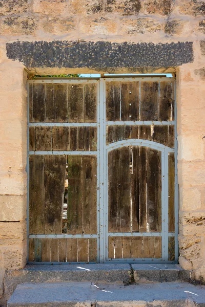 Porta de madeira antiga definida na parede de pedra — Fotografia de Stock