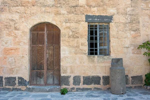 Antica porta in legno incastonata nel muro di pietra — Foto Stock