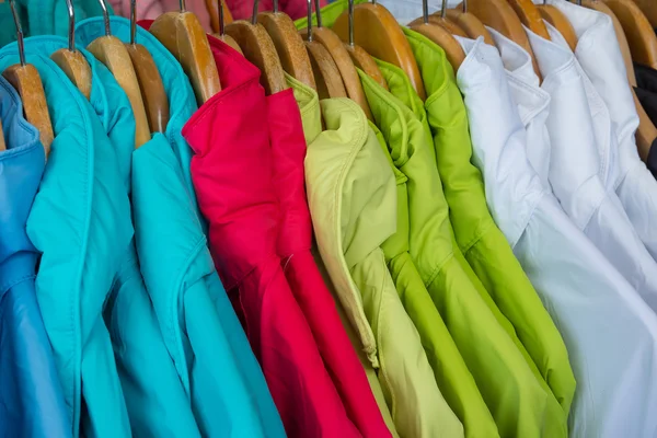 Rainproof jackets in bright colors on a rack for sale. — Stock Photo, Image