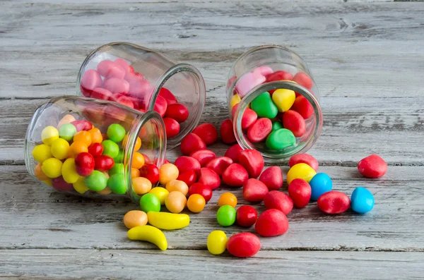 Três jarros na mesa com doces espalhados — Fotografia de Stock
