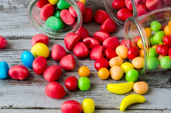 Primo piano delle caramelle rosse e gialle sparse dai barattoli — Foto Stock