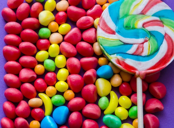 Kleurrijke lollipop op verspreide snoepjes — Stockfoto