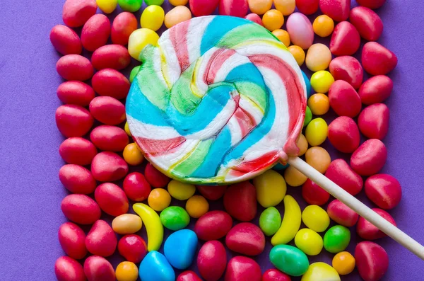 Lollipop on bright multicolored candies — Stock Photo, Image