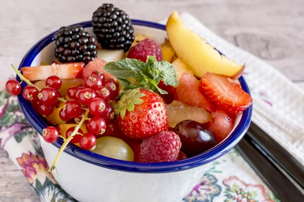 Primer plano de frutas y bayas en un tazón sobre la mesa —  Fotos de Stock