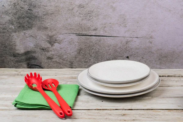 Teller Mit Küchentüchern Und Kochutensilien Auf Einem Holztisch — Stockfoto