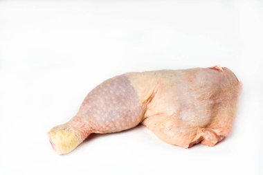 Beyaz arka planda çiğ tavuk budu.