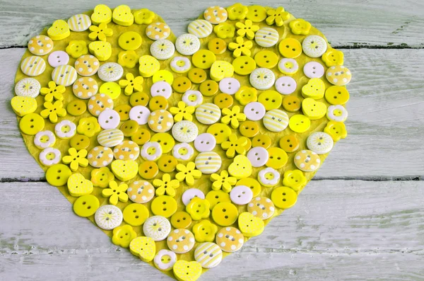 Yellow heart covered with colorful buttons. — Stock Photo, Image