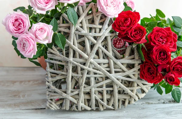 Κοντινό πλάνο της χειροποίητα ξύλινα καρδιάς, διακοσμημένη με κόκκινα και ροζ τριαντάφυλλα — Φωτογραφία Αρχείου