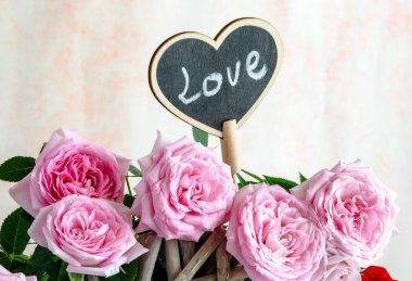 El yapımı ahşap kalp kırmızı ve pembe güller arasında