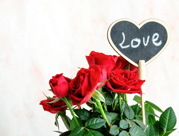 Ručně vyráběné dřevěné srdce mezi červené a růžové růže — Stock fotografie