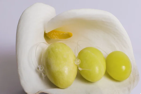 Le uova di giada si trovano su un fiore bianco Foto Stock
