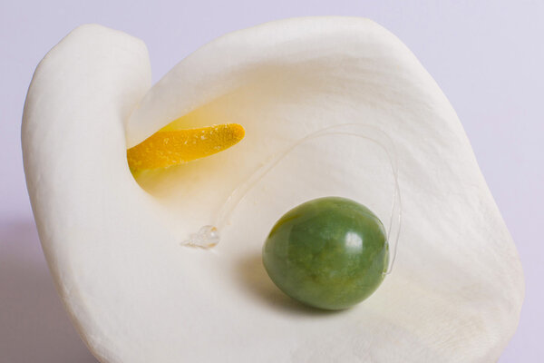 Jade egg lie on a white flower