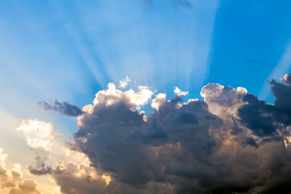 Nuvens no céu azul e raios de sol — Fotografia de Stock