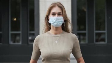 Maskeli kız Corona virüsüne yakından bakıyor. İnsanlar maske takıyor.