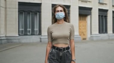 Maskeli İtalyan kadın boş sokak koronavirüsünde yürüyor. Covid-19 tiyatrosuna yakın bir model.