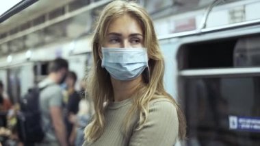Maskeli kadın metro koronavirüsü taşıyor. Kalabalık yolcular covid-19 'u çalıştırıyor..