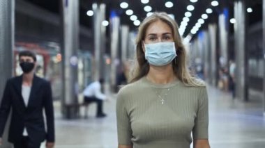 Maskeli kalabalık metro koronavirüsünde yürüyor. Metrodaki kadın Covid-19